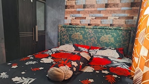 Ein Schlafzimmer mit einem Bett, einem Kleiderschrank und einer Wand mit Ziegelmuster.