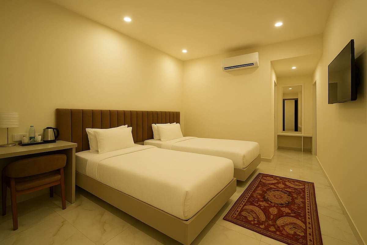 A hotel room with two beds, a desk with a chair, an air conditioning unit, a TV, and a patterned rug.