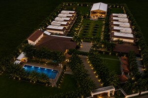 An aerial view of a resort with multiple buildings, a swimming pool, and landscaped areas. - Veerdency Luxury Resort - 3 Km to Banglore Airport Hotel (Devanahalli)