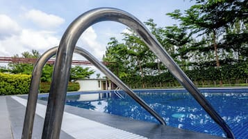 A metal poolside structure with a tiled walkway leading to a pool.