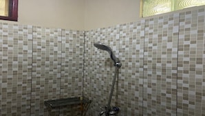 A shower area with tiled walls and a metal showerhead.