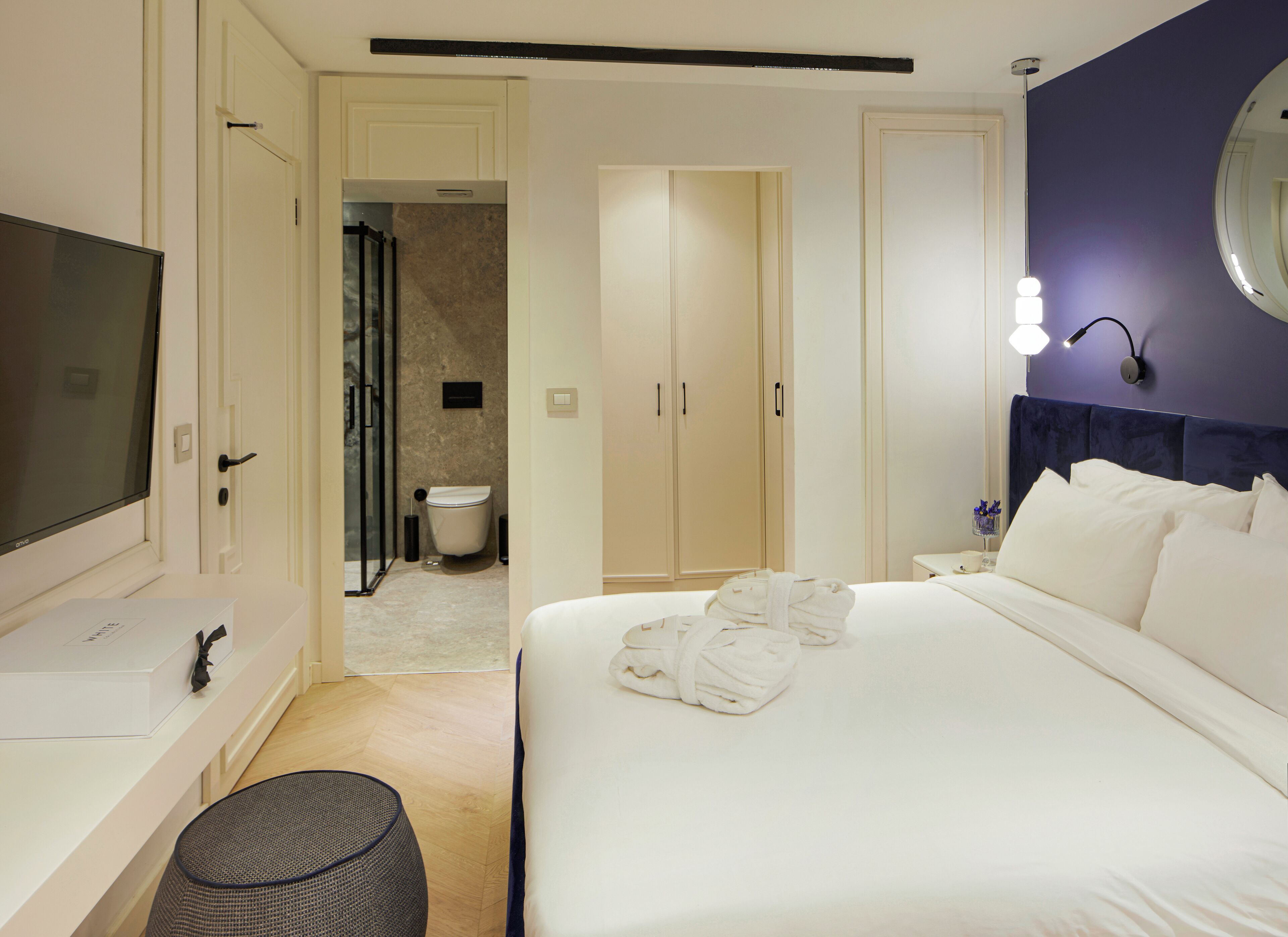 Habitación de hotel con cama, televisión, baño y armario.