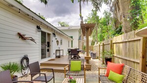 Eine Terrasse mit Gartenmöbeln, einer Pergola und einem Holzzaun.
