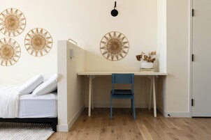 A bedroom with a bed, a desk, and a chair.
