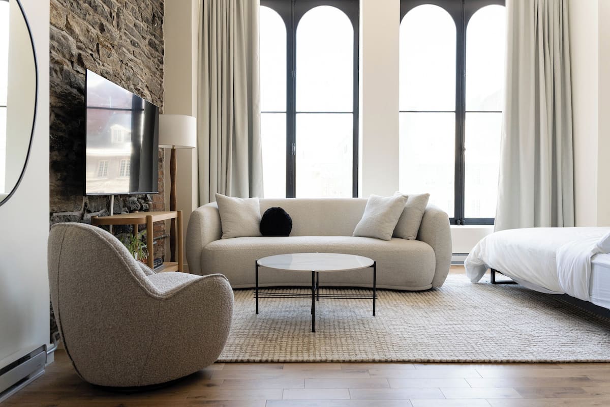 A modern living room with a sofa, armchair, and a coffee table.