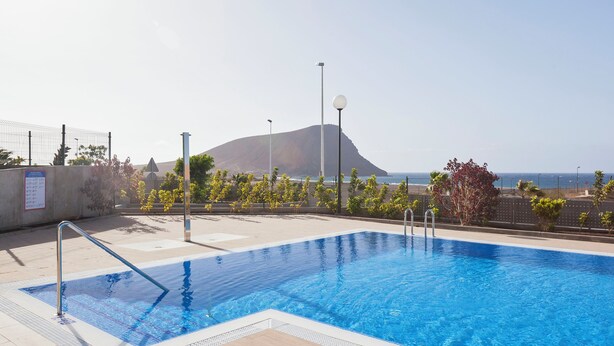 A swimming pool with a view of the ocean and a mountain in the background. - Ocean Paradise 2 la Tejita (Intero appartamento, due camere e un bagno) (Granadilla de Abona)