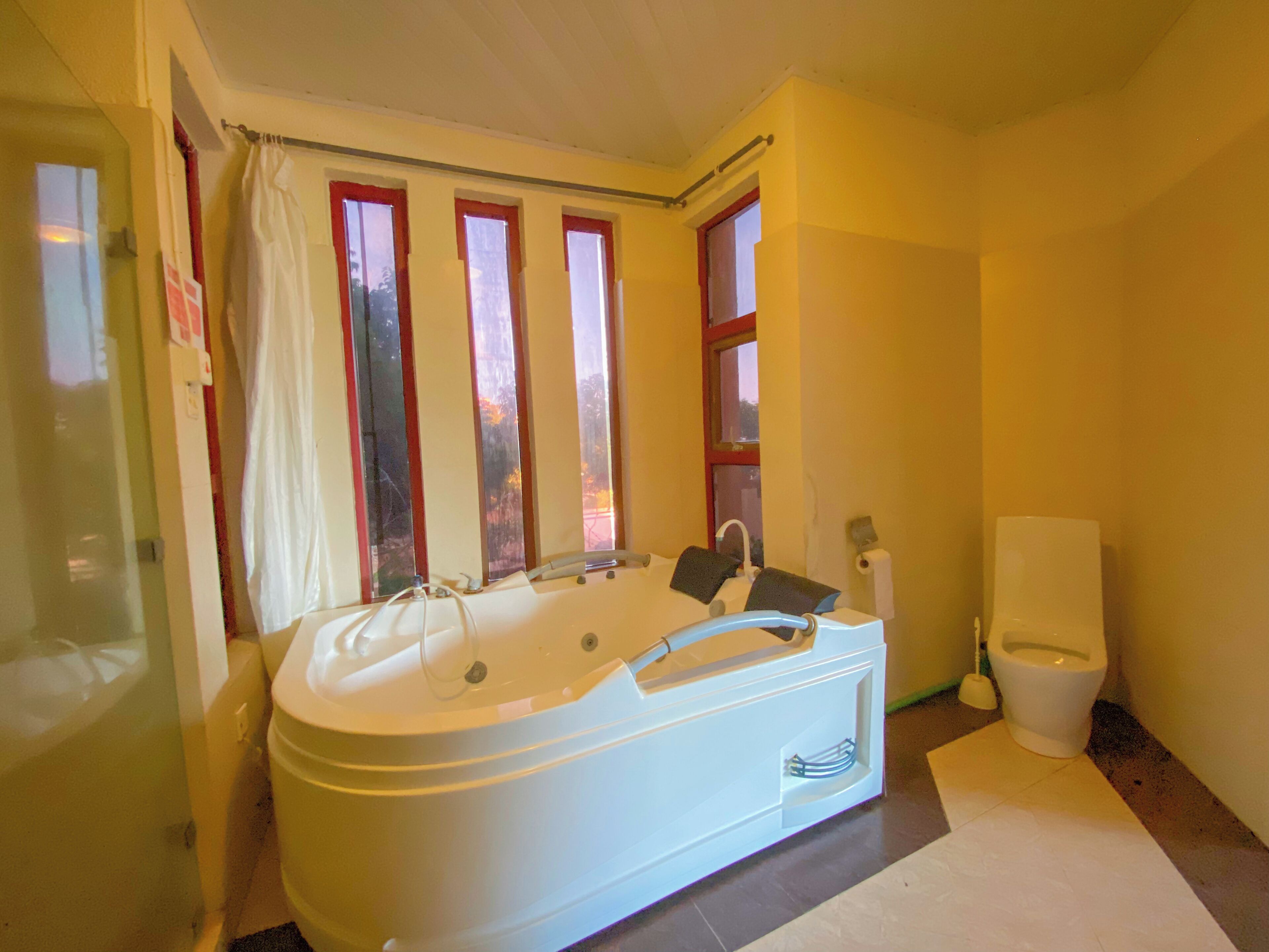 A bathroom with a bathtub, a toilet, and a shower curtain.