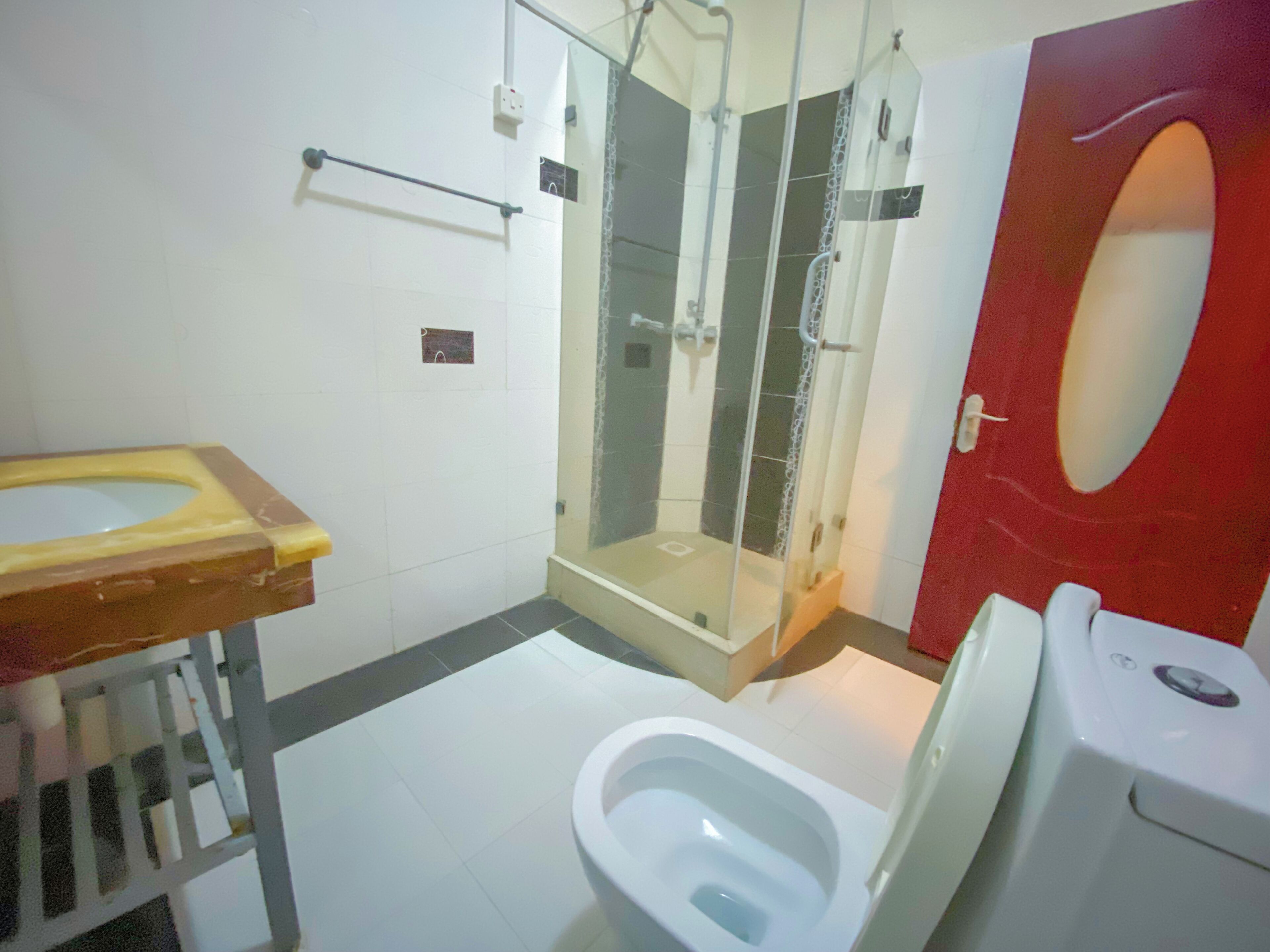Une salle de bain comprenant des toilettes, une douche avec des parois en verre et un lavabo.