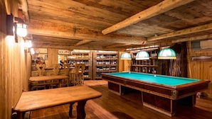 A wooden interior with a pool table, wooden benches, and shelves with bottles. - Hotel Lyshaus di Gressoney Saint Jean (Gressoney-Saint-Jean)