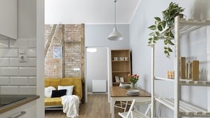 Een moderne keuken met witte kasten, een houten aanrecht en een hangplant.