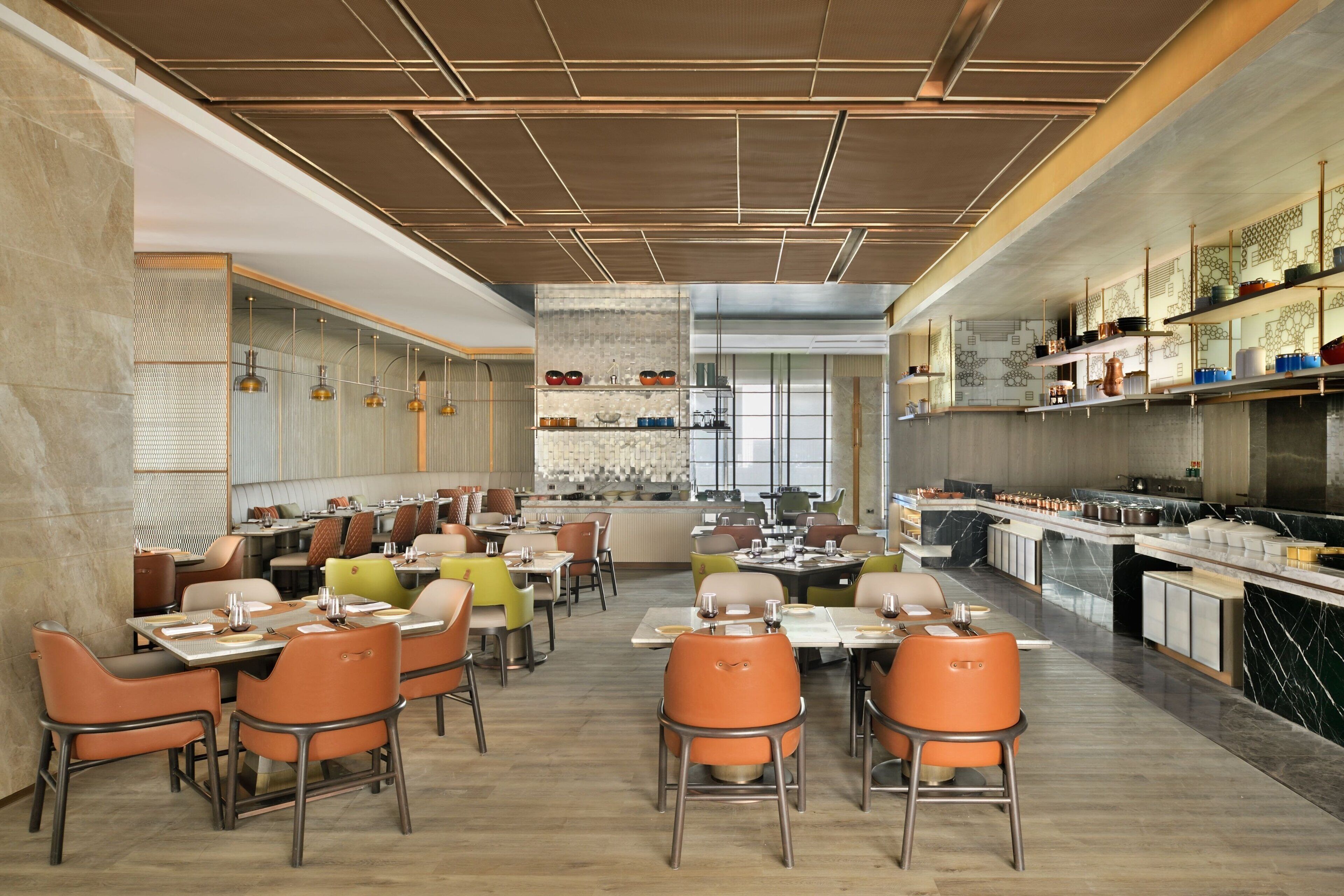 A spacious restaurant with high ceilings, modern lighting, and a variety of seating arrangements.