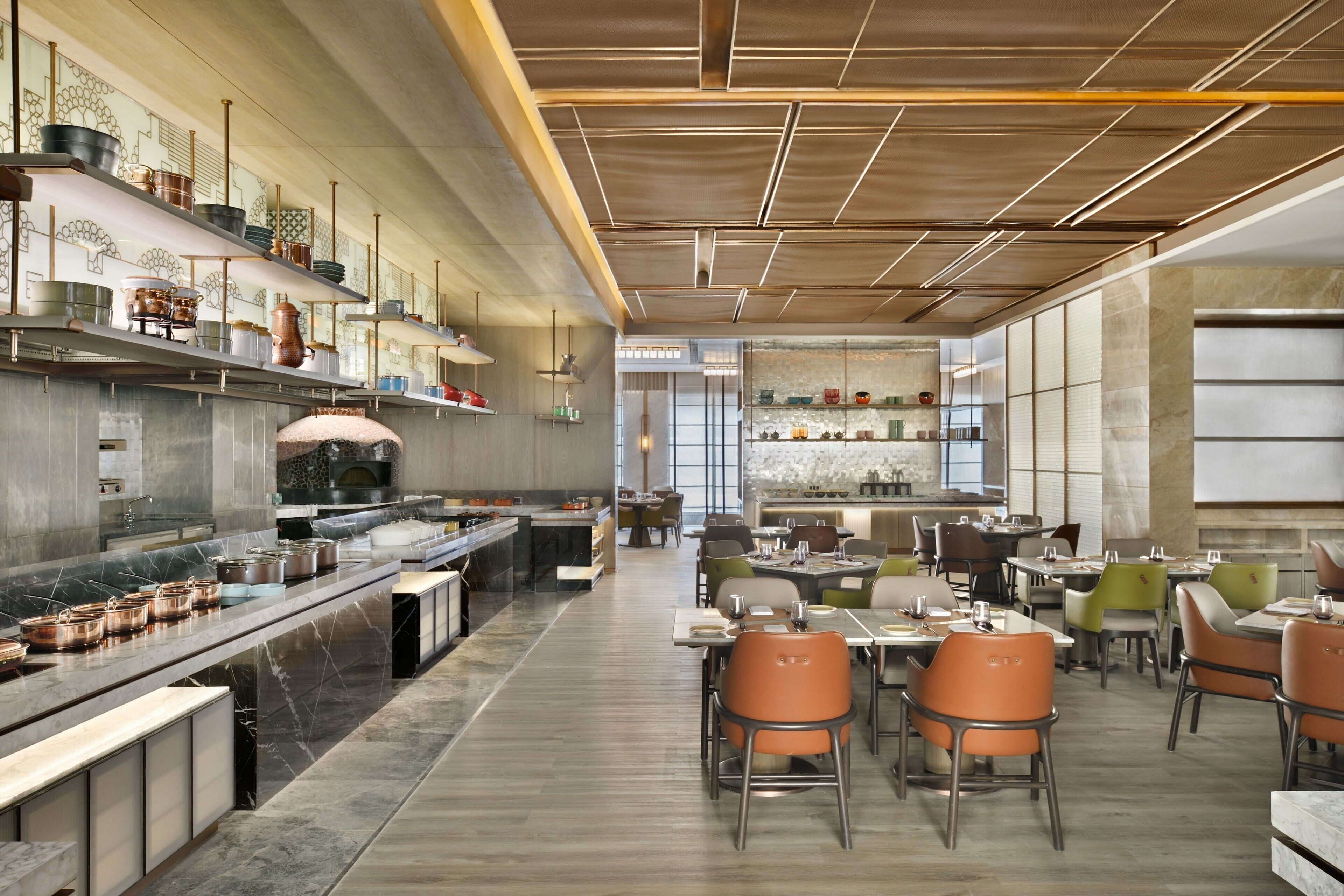 Un restaurant moderne doté d’un long comptoir, de plusieurs tables et de chaises.
