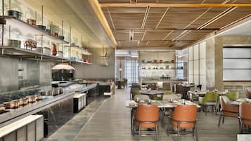 Un restaurant moderne doté d’un long comptoir, de plusieurs tables et de chaises.