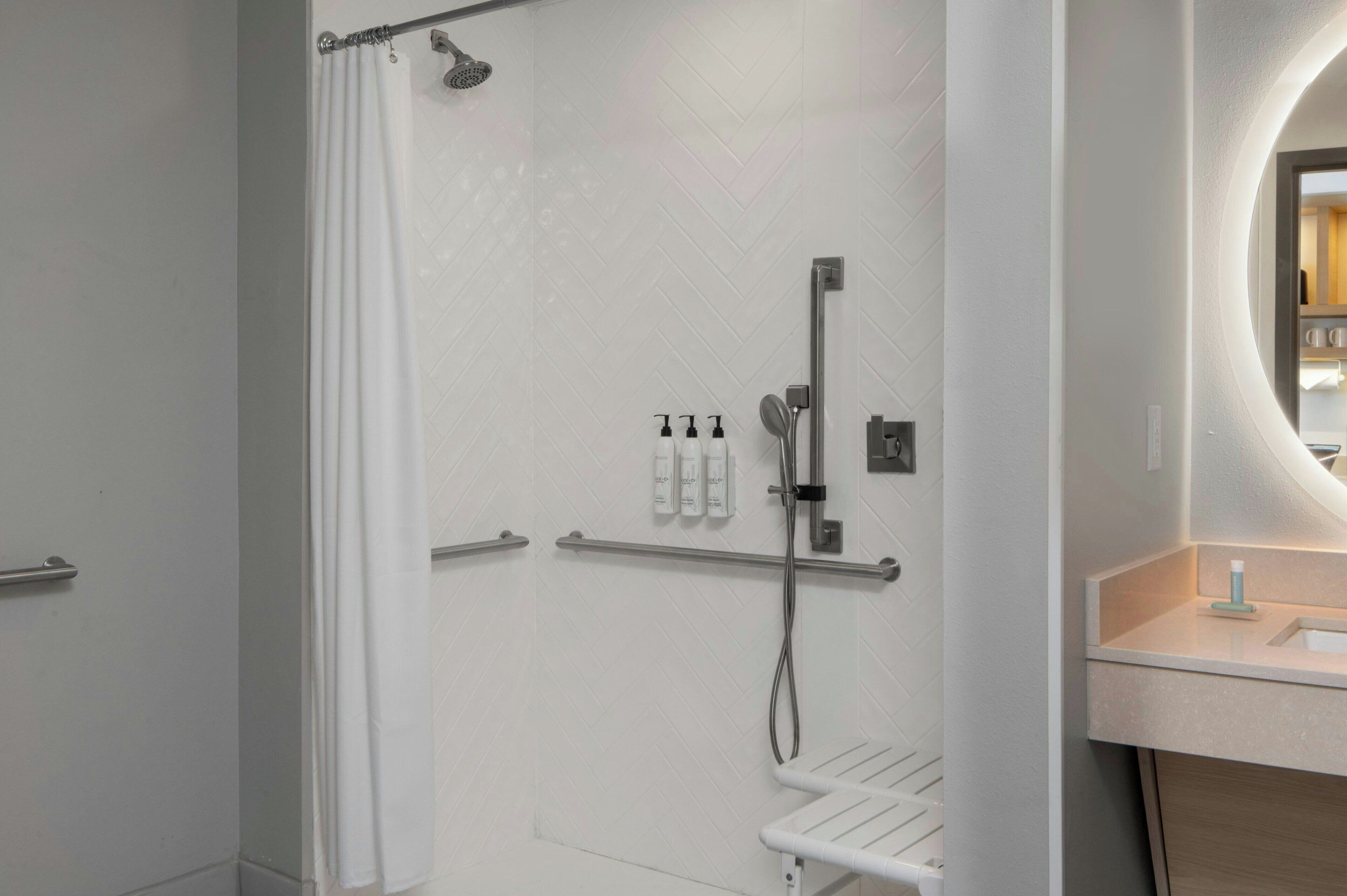 A modern bathroom with a shower, toilet, and sink.
