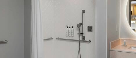 A modern bathroom with a shower, toilet, and sink.