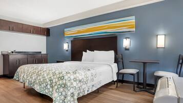 Una habitación de hotel con una cama, un escritorio y una silla.