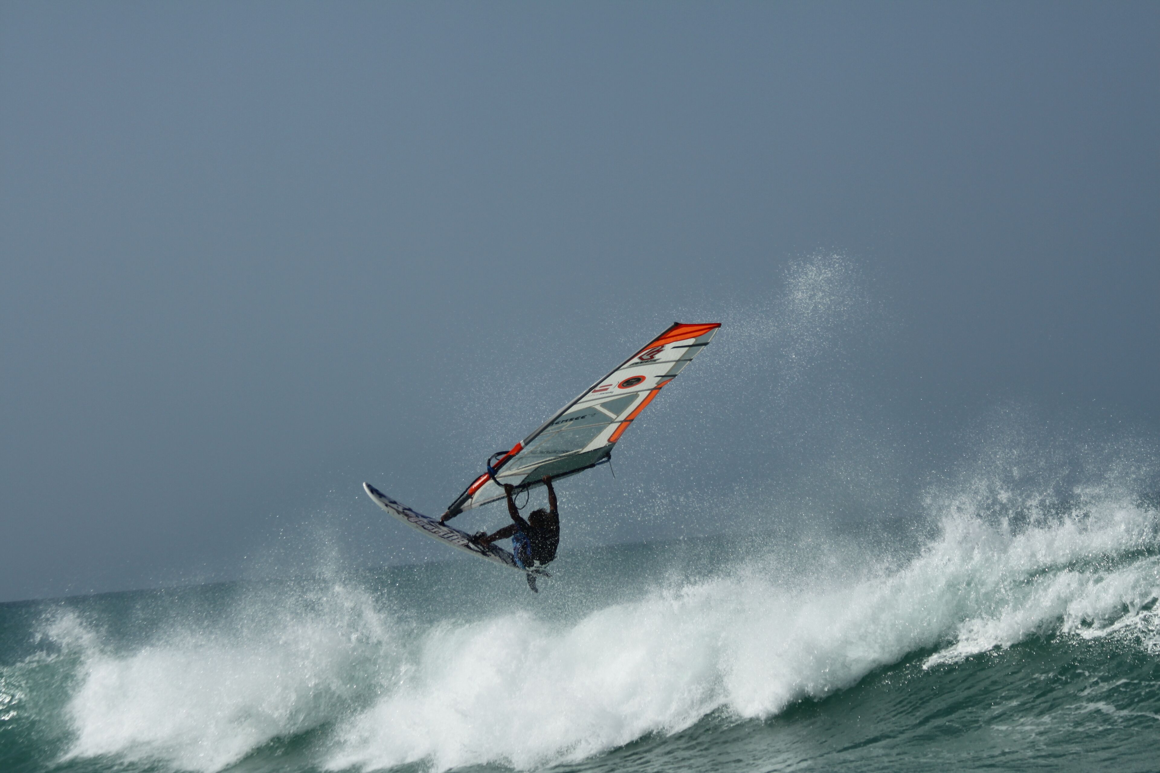 A person windsurfing on a wave.