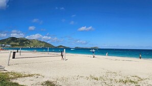 A beach with a volleyball net, clear blue sky, and calm sea. - " Casanova House" à 2 Minutes à Pied des Restaurants et 5 Minutes de la Plage (Saint Martin)