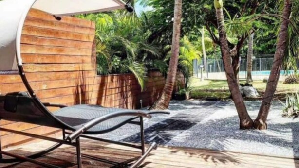 A wooden deck with a lounge chair and a canopy structure. - " Casanova House" à 2 Minutes à Pied des Restaurants et 5 Minutes de la Plage (Saint Martin)
