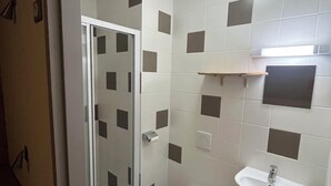Een badkamer met toilet, wastafel en douche.