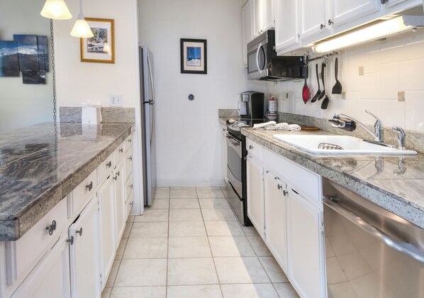 A modern kitchen with granite countertops, stainless steel appliances, and white cabinetry. - Ski Condo, Short Walk to Lionshead Slopes and Shops. Hot Tubs and Mountain Views (Vail)