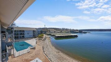 A waterfront hotel with a swimming pool, docked boats, and a view of the lake.