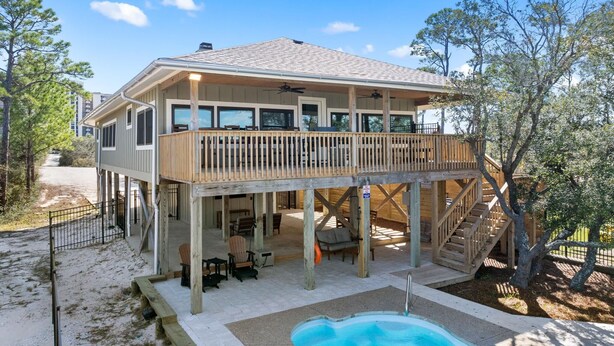 A two-story house with a balcony, outdoor seating, and a swimming pool. - Cotton Bayou Fish Camp (Orange Beach)