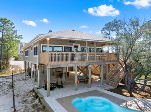 A two-story house with a balcony, outdoor seating, and a swimming pool. - Cotton Bayou Fish Camp (Orange Beach)