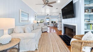 A living room with a sofa, armchairs, a TV, and a fireplace. - Cotton Bayou Fish Camp (Orange Beach)