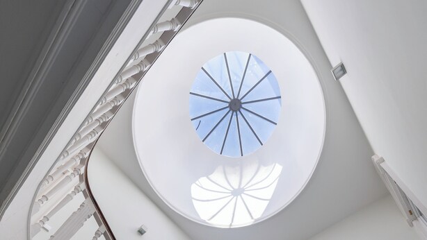 Un escalier en colimaçon surmonté d’une lucarne.