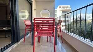 Ein Balkon mit roten Stühlen und einer Glastür, die zu einem Zimmer führt.