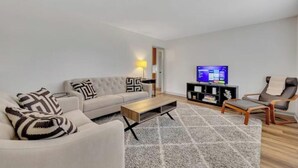 A modern living room with a sofa, coffee table, and a television.