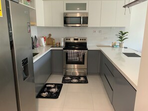 Apartamento | Cocina privada | Frigorífico, microondas, horno y placa de cocina