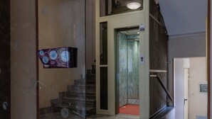 En modern inredning med en glasvägg, en trappa och en väggmonterad tv.