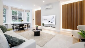 Ein modernes Wohnzimmer mit Sofa, Couchtisch und Essbereich.