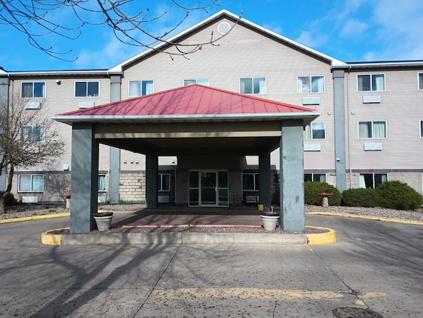 A two-story building with a covered entrance and a red roof. - Miriam Hotel (Bismarck)