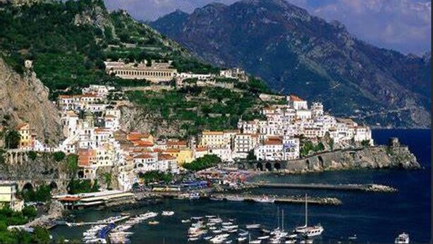 A coastal town with buildings on a hillside, a harbor with boats, and mountains in the background. - Modern and Cozy Home at 200 Meters to the Beach (Minori)