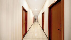 A long, narrow hotel corridor with wooden doors on both sides and a shiny tiled floor. - Binpeng Tianxia Hotel (Harbin)