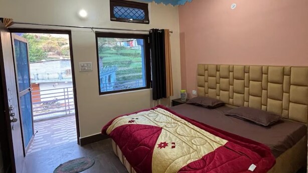 A bedroom with a bed, a window, and a door leading to an outdoor area.