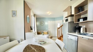 A modern kitchen with a dining area, featuring a microwave, coffee maker, and a dishwasher.