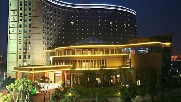 A multi-story hotel with a curved facade and a prominent entrance area. - Huatai Hotel (Tianmen)