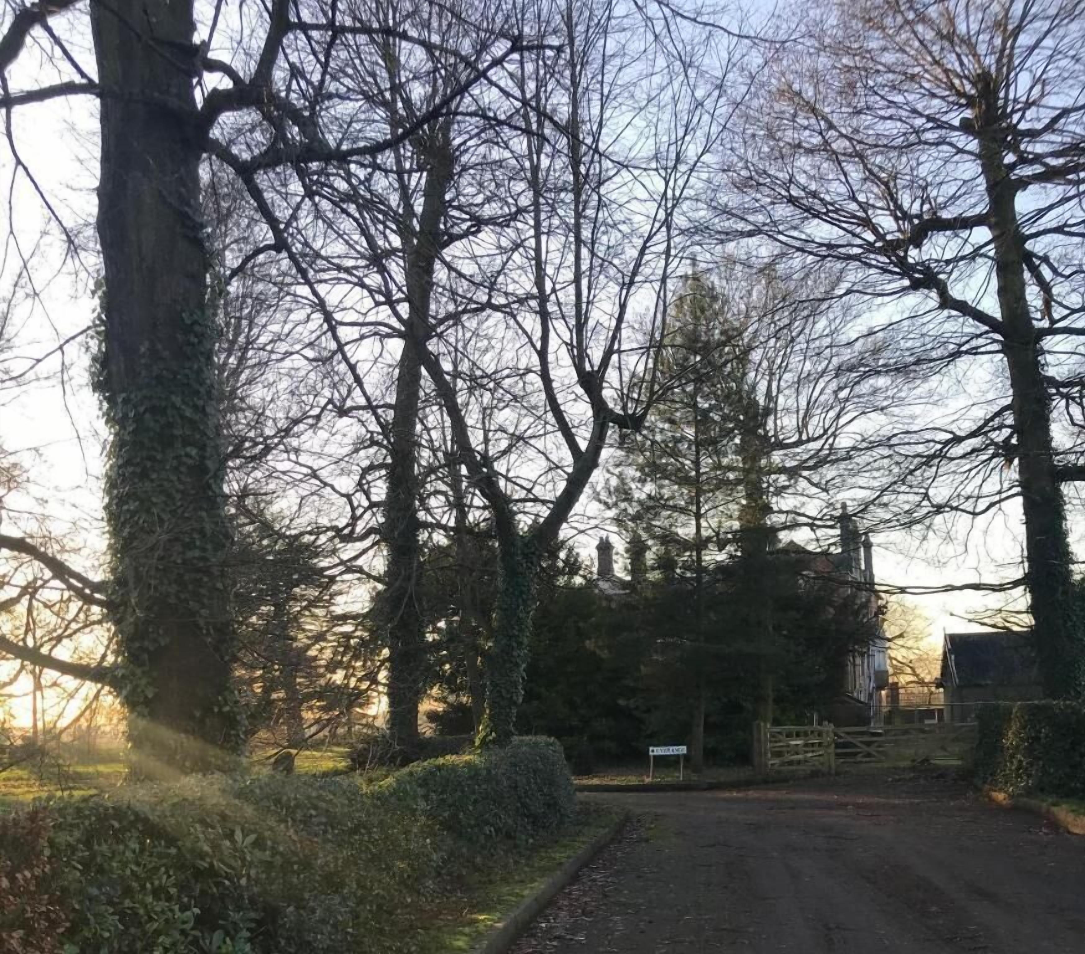 Uma estrada rural que leva a um portão com uma placa indicando 'PRIVATE'.