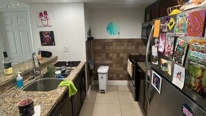 Una cocina moderna con encimeras de granito, electrodomésticos de acero inoxidable e imanes decorativos.