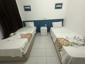 A hotel room with two single beds, a small bedside table, and a nightstand. - BODRUM LOTUS LINE HOTEL (Bodrum)