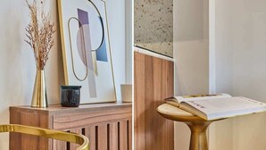 A wooden reception desk with a vase of dried plants and a framed abstract artwork. - Apartment in the Center of Paris (Paris)