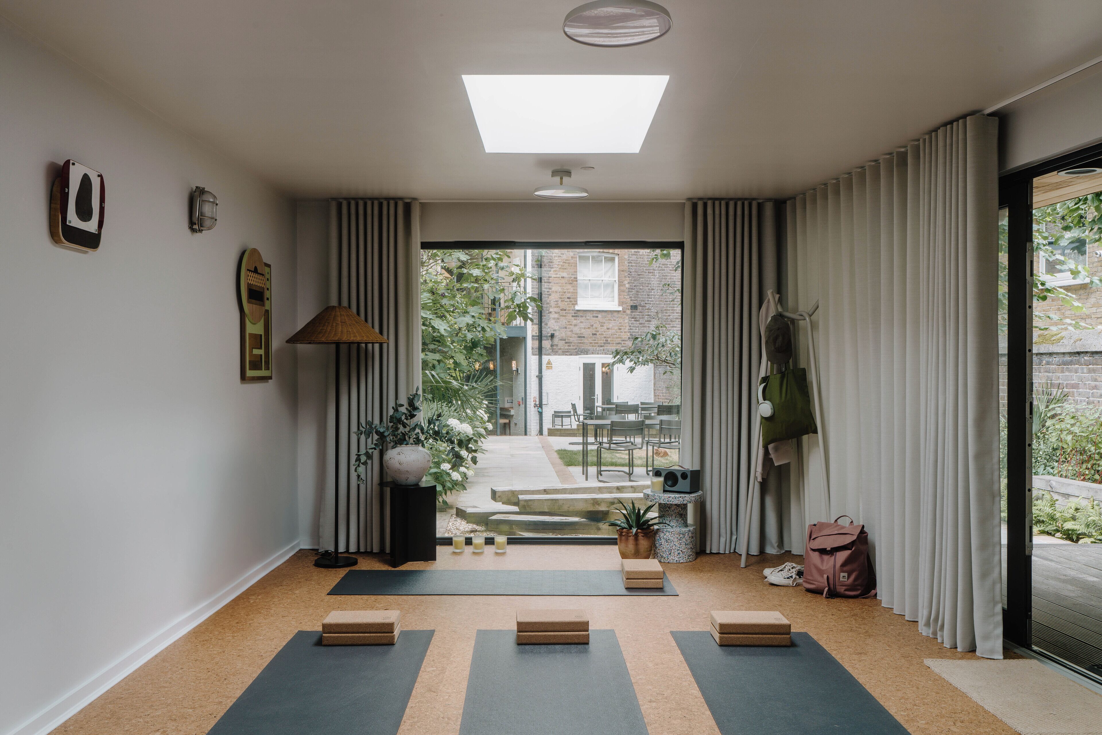 A yoga mat area with a view to a garden and a brick building.