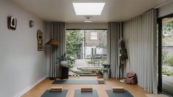 A yoga mat area with a view to a garden and a brick building.