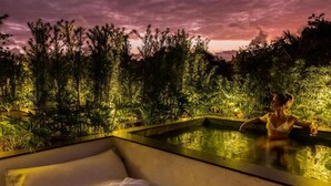 A poolside area with a lounge chair and a person relaxing. - Vila Almesca (Porto Seguro)