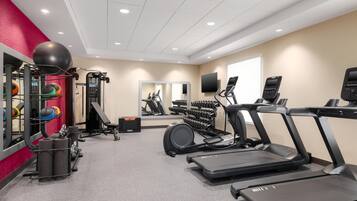 A modern gym with treadmills, weight machines, and exercise balls.