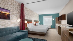 Une chambre d’hôtel avec un lit, un canapé, un bureau et une télévision.